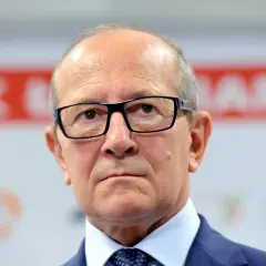 Mężczyzna w okularach, w garniturze i krawacie. Zastanawiamy się, ile lat ma Szaranowicz, patrząc na jego poważną twarz.