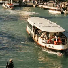 Ein belebter Vaporetto in Venedig transportiert Passagiere über das glitzernde Wasser.