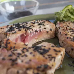 Perfekt gegrillter Thunfisch mit Sesam bestreut, serviert mit Gurkensalat. Ein Genuss für alle Sinne!