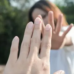 Dłoń w geście "stop" sugeruje trudną rozmowę o tym, jak zerwać z chłopakiem.