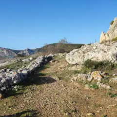 Senderos rocosos y vegetación agreste invitan a explorar qué hacer en Carboneras, con imponentes formaciones rocosas al fondo.