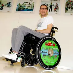 Lucas de Ulacia sonríe en su silla de ruedas, con la rueda decorada con "¡Lucas!".