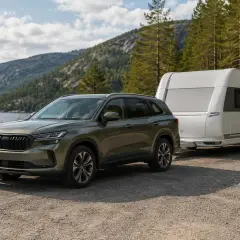 Grön Skoda Kodiaq drar en husvagn vid en sjö i Sverige. Perfekt för ett skoda kodiaq test i naturen.