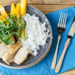Idealne danie, co jeść po treningu: grillowany kurczak, ryż, mango i rukola na talerzu.