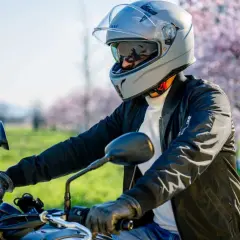 Motociclista con casco grigio, pronto per un giro. La scelta del giusto **misura casco moto** è fondamentale per la sicurezza.