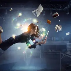 Mujer levitando en una oficina, rodeada de ideas brillantes y objetos flotantes. En pleno **flow state**, crea y trabaja con energía.