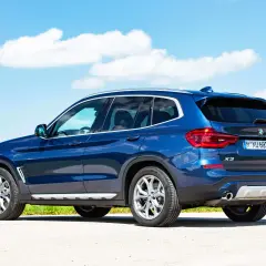 Niebieskie BMW X3 na tle błękitnego nieba. Sprawdź dane techniczne tego SUV-a.