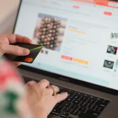 Persona compra en línea con tarjeta de crédito, dando su consentimiento explícito para la transacción.