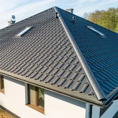 Nowoczesny dom z ciemnoszarą blachodachówką. Różne rodzaje blachodachówki oferują trwałość i estetykę.