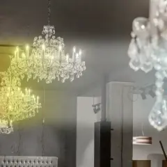 Lámpara techo cristal colores, dos candelabros de cristal brillan con luz cálida y fría, creando un ambiente elegante.