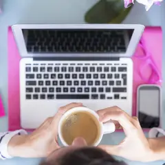 Kawa i laptop na biurku, inspiracja do tego, jaką firmę założyć.