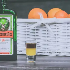 Butelka Jägermeister, kieliszek z warstwowym shotem i koszyk z pomarańczami. Idealny zestaw na wieczór z przyjaciółmi. #koktajltv