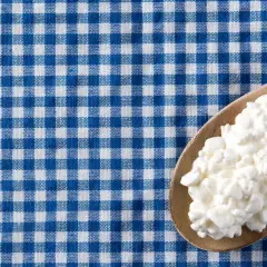 Un cucchiaio di jocca in gravidanza su una tovaglia a quadri blu e bianchi.