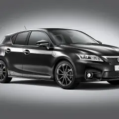 Elegancki, czarny Lexus CT200h z przyciemnianymi felgami stoi na szarym tle.
