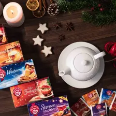 Gemütliche Teepackungen und Kerzen laden zum adventstee selber machen ein. Zimtsterne und Tannenzweige vollenden die winterliche Deko.