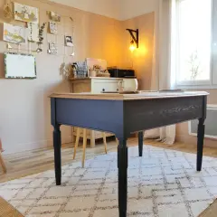Bureau en bois peint en bleu marine, avec un plateau en bois naturel. Une tasse est posée sur le bureau.