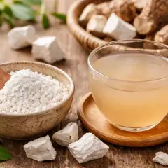Polvere bianca in una ciotola e una tazza di bevanda chiara, ingredienti naturali per il reflusso.