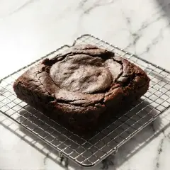 Idealny brownie, lekko popękany na wierzchu, stygnie na metalowej kratce.