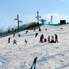 Zimowe atrakcje dla dzieci na Mazowszu: stok narciarski z wyciągiem, na którym bawią się rodziny, ucząc się jeździć na nartach i snowboardzie.