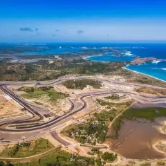 Circuito de carreras Pertamina Mandalika International Street Circuit, con vistas al mar azul y colinas verdes.