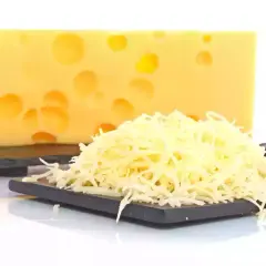 Bloque de queso suizo con agujeros y una pila de queso rallado, listo para ser queso que se derrite.