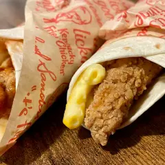 Dwa mcwrap klasyczny kcal w papierze z kurczakiem i serem. Jeden polany sosem, drugi z makaronem.