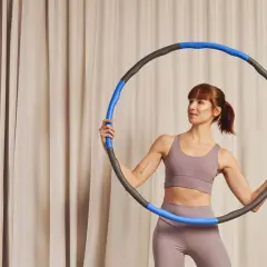 Kobieta z hula hop zastanawia się, czy hula hop odchudza. Ćwiczenia z hula hop mogą pomóc w redukcji tkanki tłuszczowej.