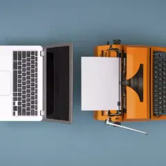 Un portátil y una máquina de escribir naranja con papel, ilustrando como se digitaliza un documento.