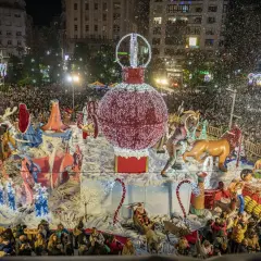 Desfile navideño en Santander con un gran adorno de bola de Navidad y figuras, rodeado de gente y confeti. Encendido luces Santander.