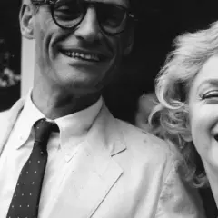 Marilyn Monroe i jej mąż Arthur Miller uśmiechają się radośnie do zdjęcia.