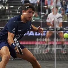 Agustin Tapia, con la sua agilità e altezza, colpisce la palla da padel in una partita intensa.