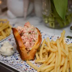 En saftig lobster roll med pommes frites och en liten skål majonnäs. En perfekt lunch!