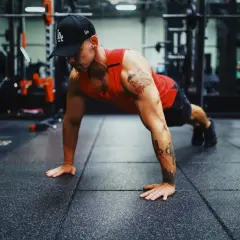 Mann in einem Fitnessstudio macht Liegestütze, um seinen Bewegungsradius zu verbessern.