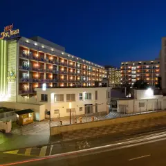 Gran Hotel Don Juan Resort nocą, z podświetloną fasadą i oknami.