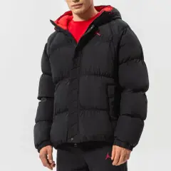 Mężczyzna w czarnej, puchowej kurtce Jordan Essentials z czerwonym wykończeniem i logo Jumpman.