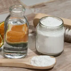 Ingrédients pour nettoyer manteau bicarbonate : citrons verts, eau, bicarbonate de soude et une brosse.