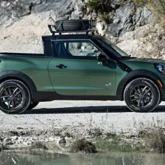 Zielony mini paceman z bagażnikiem dachowym i zapasowym kołem, gotowy na przygodę w terenie.