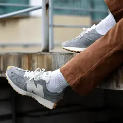 Szare New Balance na nogach w brązowych sztruksach. Zastanawiasz się, czy new balance można prać w pralce? Te wyglądają na czyste!