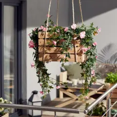 Jolie caisse en bois remplie de fleurs retombantes pour suspension, apportant une touche de couleur et de verdure à un balcon.