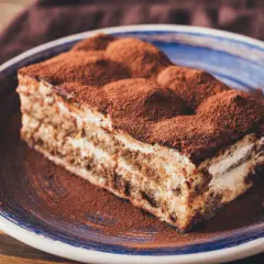 Pyszny kawałek tiramisu, co to znaczy? To włoski deser z kawą i kakao, który rozpływa się w ustach.