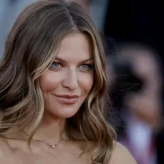 Anna Lewandowska, znana dziennikarka, zjawiskowo prezentuje się na czerwonym dywanie. Jej błękitne oczy przyciągają uwagę.