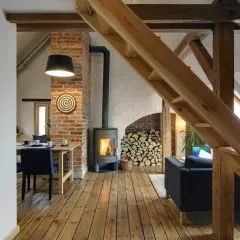 Drewniane poddasze z kominkiem, schodami, jadalnią i salonem.