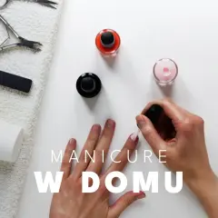 Dłoń malująca paznokcie lakierem, obok buteleczki z lakierami i akcesoria do manicure.