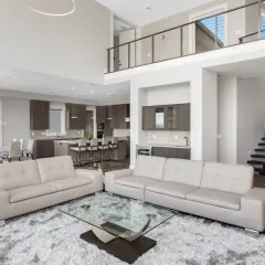 Spacious modern living room with a kitchen and dining area, captured with a real estate photography lens to showcase its open-concept design.