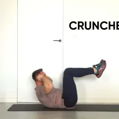 Mężczyzna wykonuje ćwiczenie ab crunch na macie.