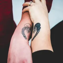 Dwie ręce z tatuażami czaszek w kształcie serca. To jedne z najlepszych tatuaży, jakie można sobie wyobrazić, symbolizujące wieczną miłość.