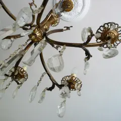 Dettagli di un lampadario a gocce in ottone con cristalli trasparenti. Un'idea su come rimodernare un lampadario a gocce con un tocco di eleganza.