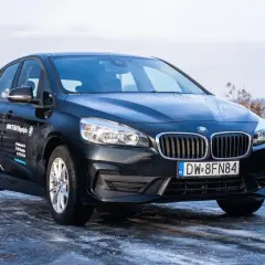 Czarny BMW 2 Active Tourer na oblodzonej drodze, gotowy na zimowe wyzwania.