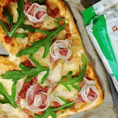 Serce z pizzy z szynką i rukolą obok mąki "Maka na pizzę włoską" - idealna do domowego wypieku.