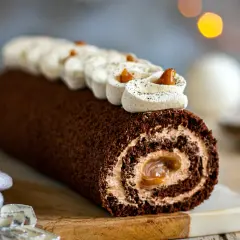 Une délicieuse buche chocolat au lait, roulée et garnie de crème onctueuse, prête à être dégustée.